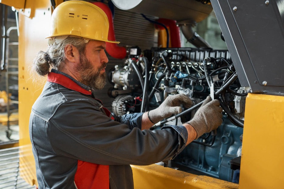 Technician performing standby generator diagnostics on an industrial backup power system engine