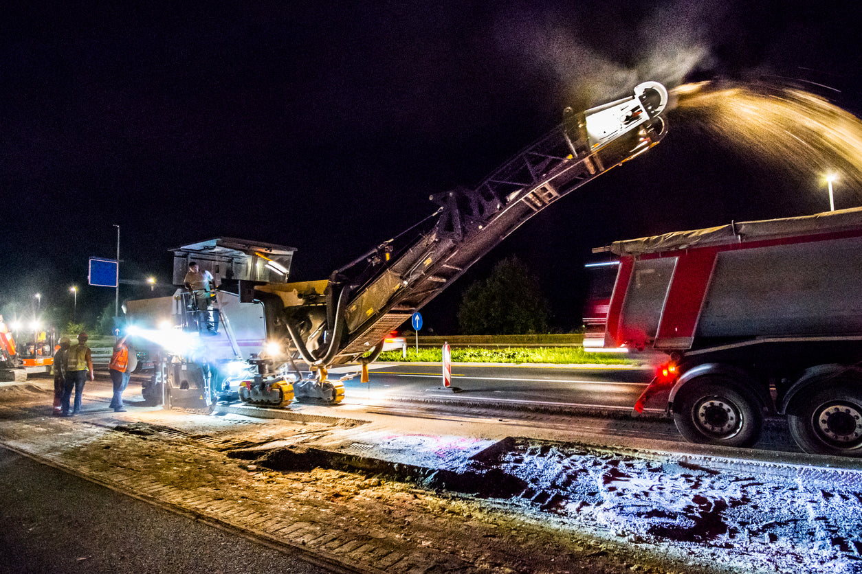 Roadside construction going on a night with a lot of lighting powered by rental generators. 
